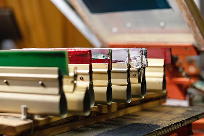 Squeegees on wooden shelve of the print screening apparatus